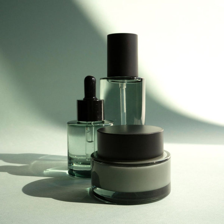 Minimal skincare bottles in soft sage light